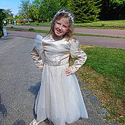 Ema participe au concours pour gagner de l'argent avec cette photo : child, daylight, dress, flower_crown, girl, golden, grass, greenery, happy, headband, nature, outdoor, park, path, posing, sandals, smiling, sunny, trees, white_skirt