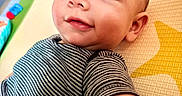 Hudson joined the competition — help win amazing prizes! baby, child, face, smile, striped_shirt, play_mat, curious, indoor, portrait, close_up, young_child, infant, person, cute, arm, head, skin, toy, colorful, background