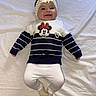 baby, smiling, lying_down, headband, bow, sweater, minnie_mouse, striped_clothing, white_leggings, socks, infant, cute, happy, child, portrait, indoors, fabric, clothing, person, young_child