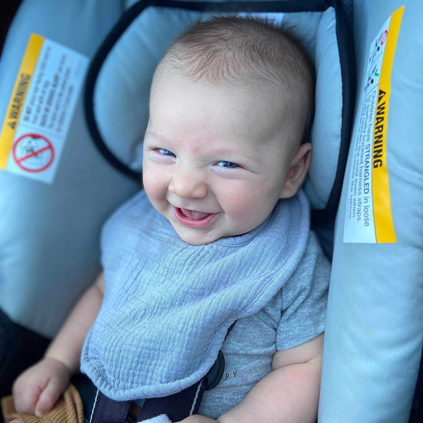 Elijah is registered to the contest to win money with this photo: baby, bib, blue_eyes, car_seat, child, closeup, clothing, cute, fabric, hand, happy, head, indoor, infant, little_baby, portrait, seatbelt, sitting, skin, smile