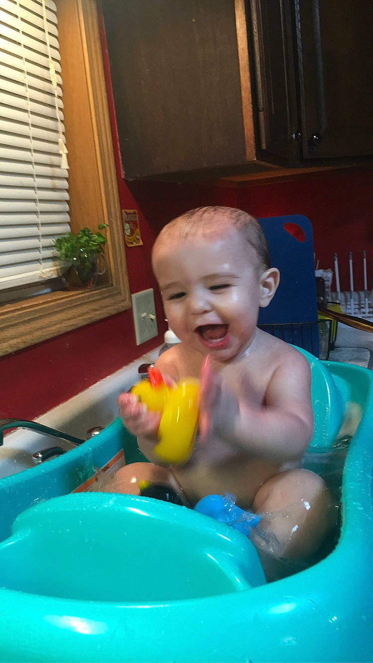 Vincent is registered to the contest to win money with this photo: baby, baby_products, baby_toys, bath_toy, bathing, blue, chest, child, fun, houseplant, leisure, person, plant, plastic, room, smile, toddler, water, window, window_blind