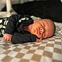 Sandro participe au concours pour gagner de l'argent avec cette photo : baby, newborn, sleeping, infant, black_clothing, skeleton_outfit, checkered_blanket, closeup, portrait, peaceful, soft_lighting, indoor, resting, cute, small_hands, face, head, skin, child, cozy
