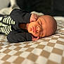 Sandro participe au concours pour gagner de l'argent avec cette photo : baby, newborn, sleeping, infant, black_clothing, skeleton_design, bedspread, checkered_pattern, soft_light, closeup, portrait, peaceful, resting, indoors, human, child, cute, hands_near_face, cozy, warm