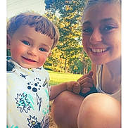 Anthony is registered to the contest to win money with this photo: child, toddler, smiling, young_woman, outdoor, daylight, grass, trees, holding_hands, happy, portrait, nature, sunlight, casual_clothing, people, friendship, joy, closeup, blue_eyes, park