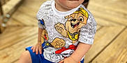 Anthony is registered to the contest to win money with this photo: child, toddler, boy, blue_eyes, short_hair, sitting, wooden_deck, casual_clothing, paw_patrol, shirt, shorts, barefoot, outdoor, daylight, smile, curious, cute, portrait, playful, young
