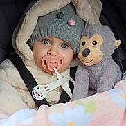 Aitana a rejoint le concours — aidez-le/la à gagner de superbes lots ! baby, blanket, blue_eyes, car_seat, child, coat, cute, floral_blanket, fur_coat, hat, indoors, infant, knit_hat, monkey_toy, pacifier, plush_toy, portrait, straps, warm, winter_clothing