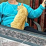 blue_sweater, casual, cat, chair, cozy, fence, fur, hands, key_fob, lap, orange_cat, outdoor, person, pet, phone, relaxing, resting, seated, snuggling, table