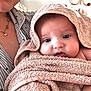 Daisy is registered to the contest to win money with this photo: adult, baby, blanket, child, closeup, comfort, cozy, cute, eyes, face, holding, home, hood, indoor, person, portrait, skin, smile, towel, warm