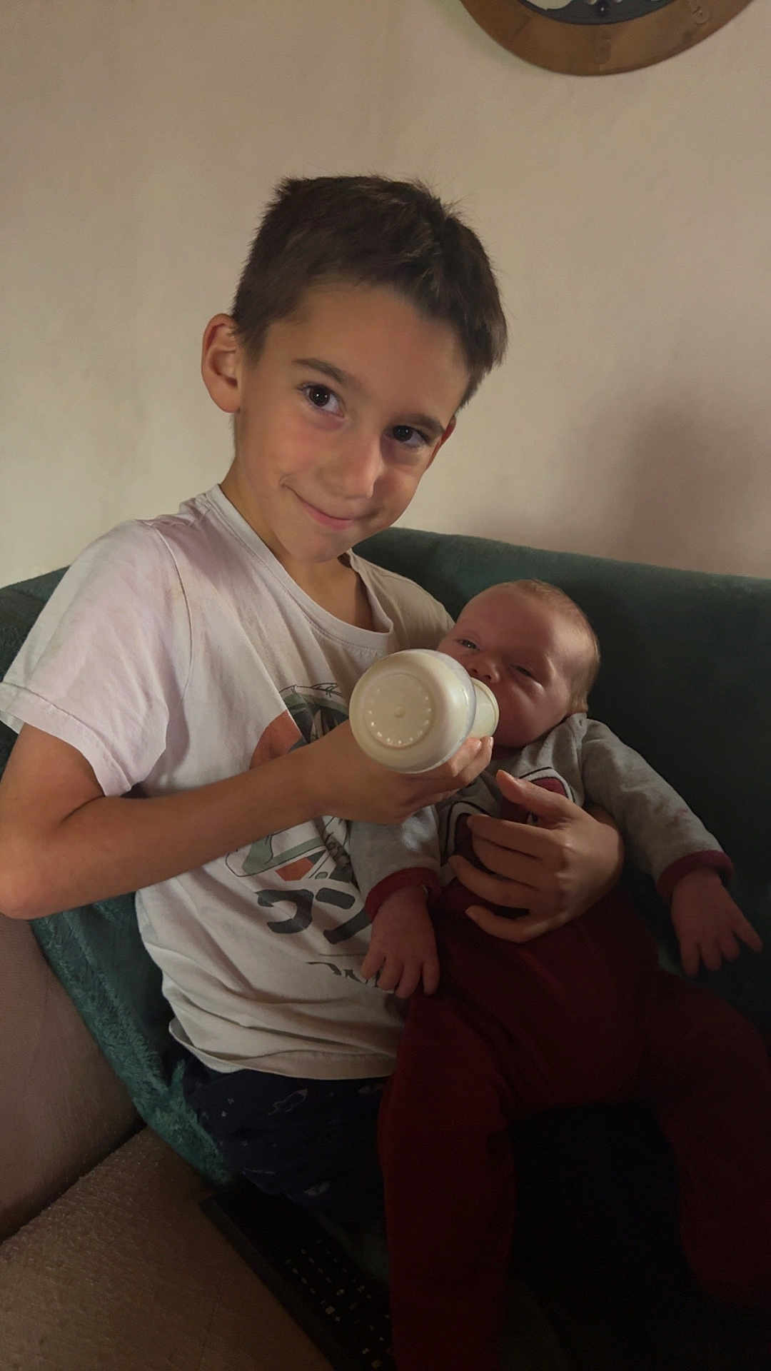 Miguel a rejoint le concours — aidez-le/la à gagner de superbes lots ! child, baby, feeding, bottle, smile, couch, blanket, toddler, boy, indoors, clothing, person, sitting, cute, family, home, relaxing, young, infant, care