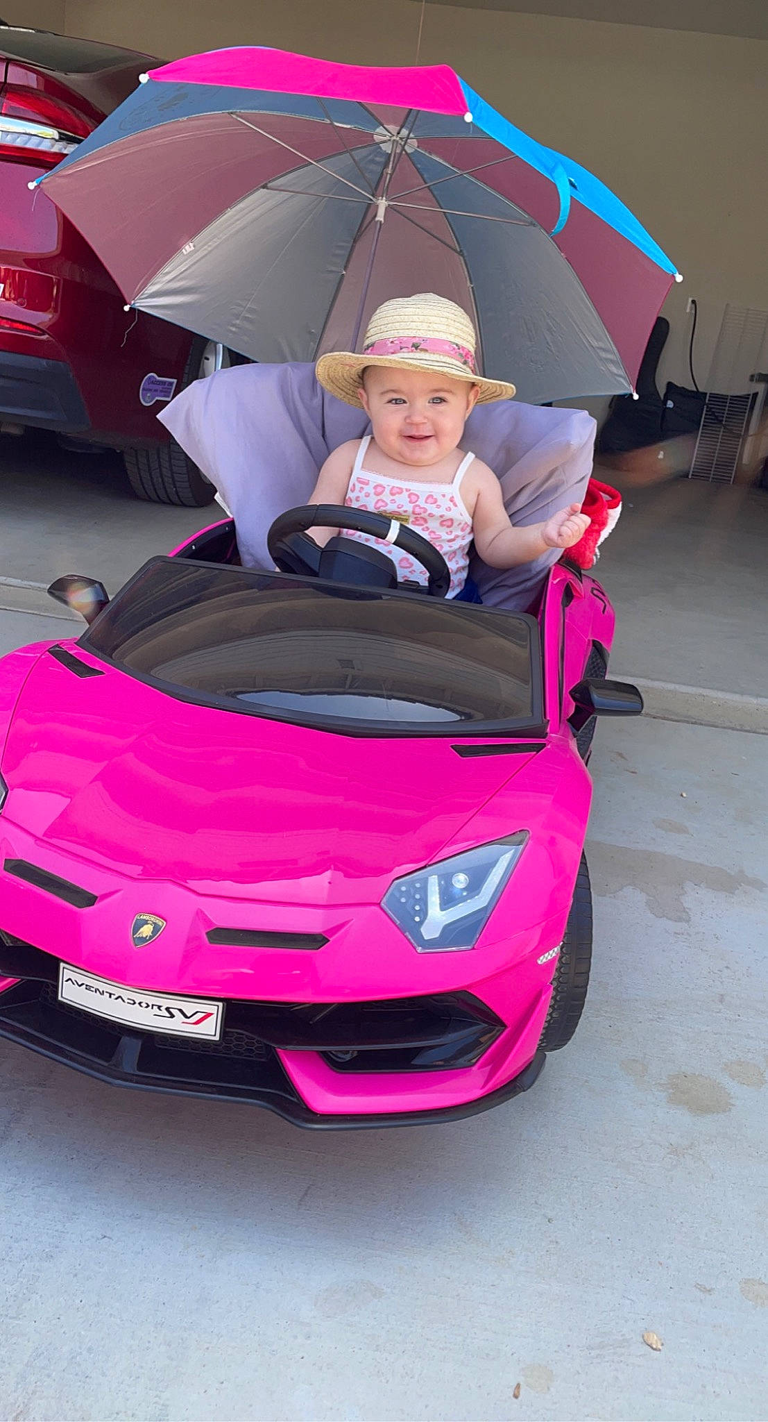 Rosalina is registered to the contest to win money with this photo: automotive_design, automotive_exterior, automotive_lighting, automotive_tire, bumper, car, grille, headlamp, headwear, hood, jeans, joy, motor_vehicle, person, pink, red, tire, umbrella, vehicle, vehicle_door