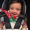 baby, infant, child, smiling, happy, car_seat, harness, portrait, face, eyes, teether, pacifier_clip, toy, floral, red, green, indoor, seated,  안전, close_up