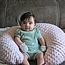 baby, infant, child, portrait, sitting, indoors, couch, pillow, blanket, mint_green_outfit, mittens, striped_mittens, bare_feet, brown_hair, wide_eyes, looking_at_camera, home, furniture, soft_texture, photography
