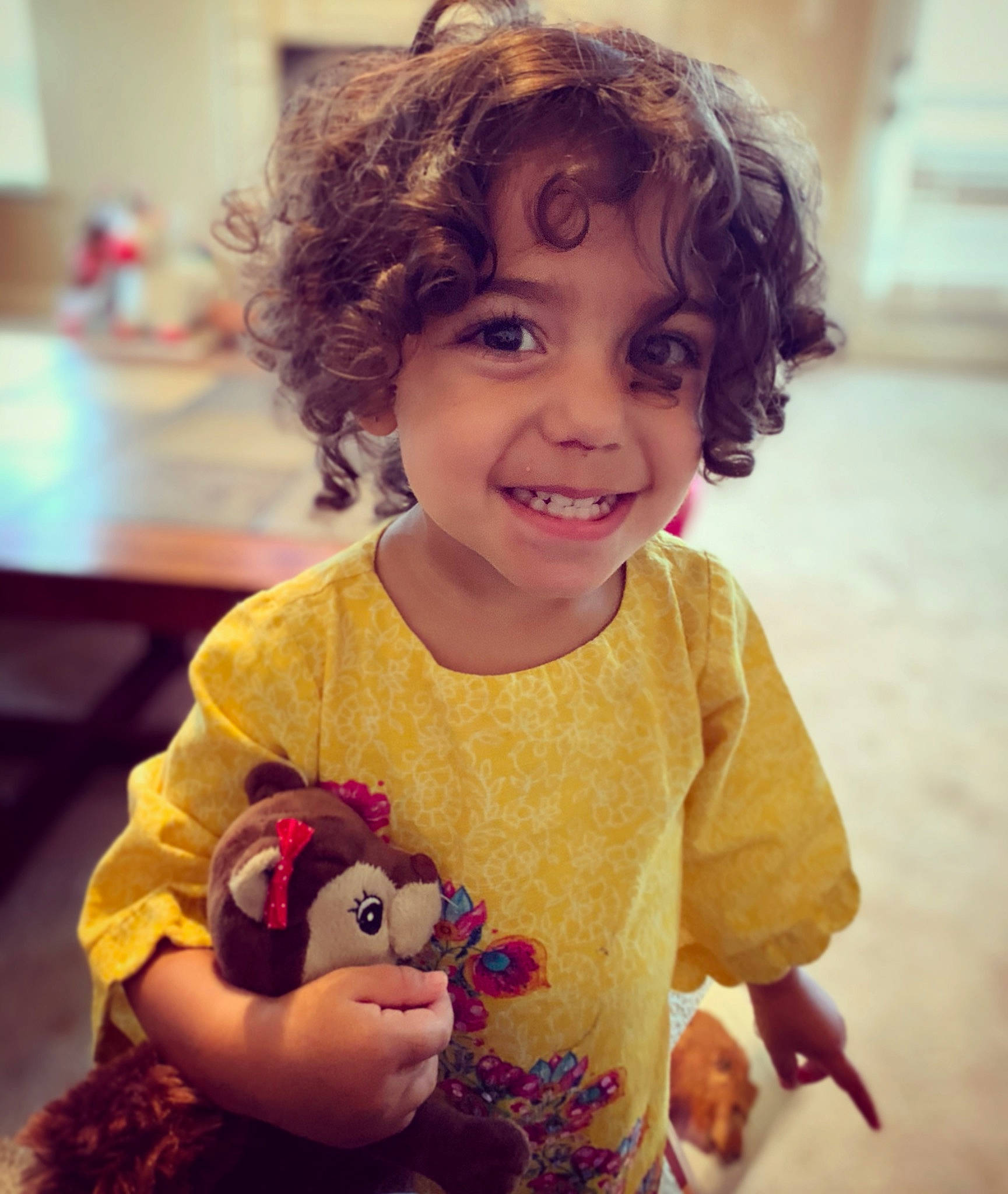 Meena is registered to the contest to win money with this photo: brown_hair, cheek, child, ear, eye, face, hair, hairstyle, head, joy, lip, nose, organ, person, play, skin, smile, stuffed_toy, toddler, tooth