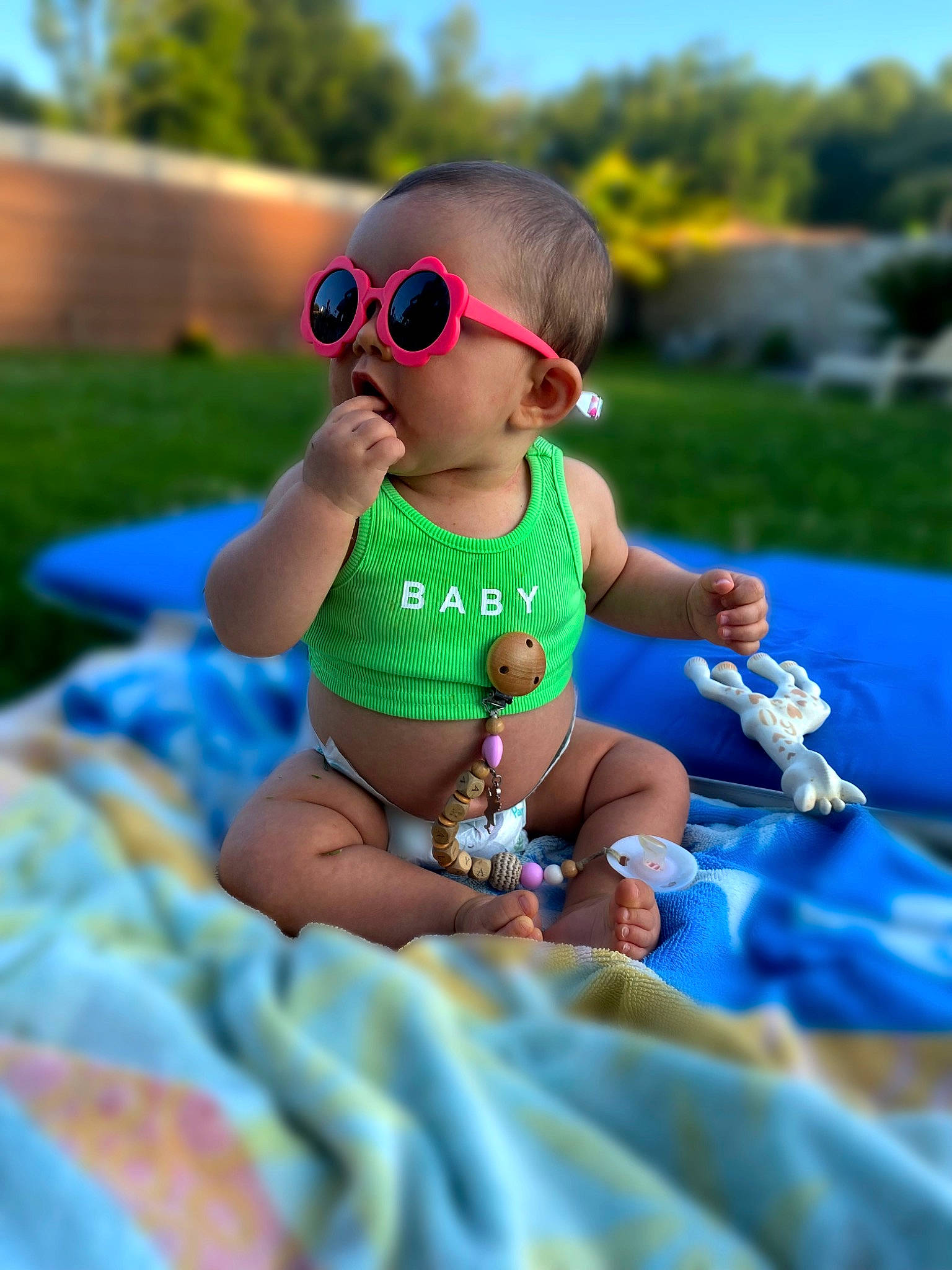 Amalya a rejoint le concours — aidez-le/la à gagner de superbes lots ! baby, baby_toddler_clothing, child, electric_blue, eyewear, finger, fun, glasses, goggles, grass, happy, leisure, person, plant, recreation, sitting, sky, summer, sunglasses, toddler