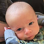 Clayton joined the competition — help win amazing prizes! baby, infant, face, expression, camouflage_clothing, closeup, soft_texture, resting, indoors, child, person, cute, young, head, eyes, skin, casual, portrait, young_child, baby_clothes