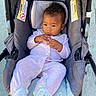 Paris is registered to the contest to win money with this photo: baby, infant, stroller, outdoor, pajamas, pink_clothing, footwear, slippers, child, person, cute, seated, baby_girl, casual, daylight, curious, hands, expression, transport, wheels
