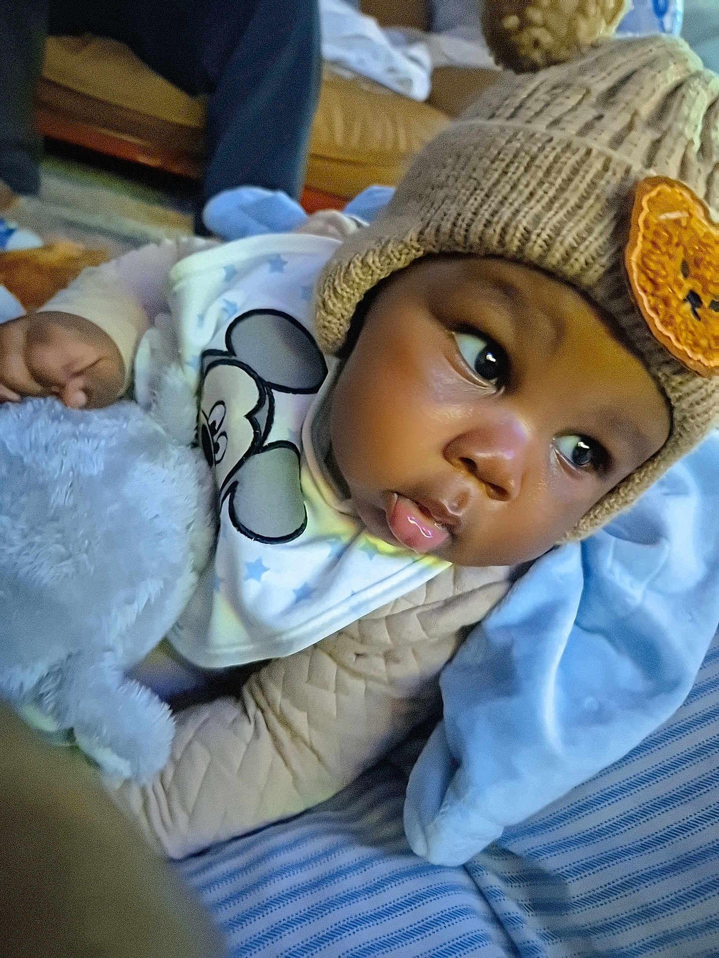 Praise is registered to the contest to win money with this photo: adult, baby, beanie, bodypart, bonnet, cap, clothing, couch, face, finger, furniture, glove, hand, hat, head, knitwear, male, man, newborn, person