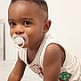 toddler, child, pacifier, curious, indoor, white_background, short_hair, sleeveless_shirt, brown_skin, portrait, closeup, cute, young_child, looking, baby, infant, expression, face, arm, casual_clothing