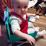 Kierstleigh joined the competition — help win amazing prizes! toddler, child, indoor, chair, red_clothing, white_tights, wooden_floor, person, sitting, toy, serious_expression, boots, floor, seated, furniture, people, background, hand, baby, young_child