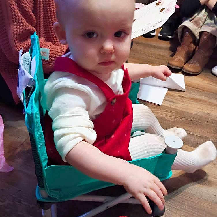 Kierstleigh joined the competition — help win amazing prizes! baby, background, boots, chair, child, floor, furniture, hand, indoor, people, person, red_clothing, seated, serious_expression, sitting, toddler, toy, white_tights, wooden_floor, young_child