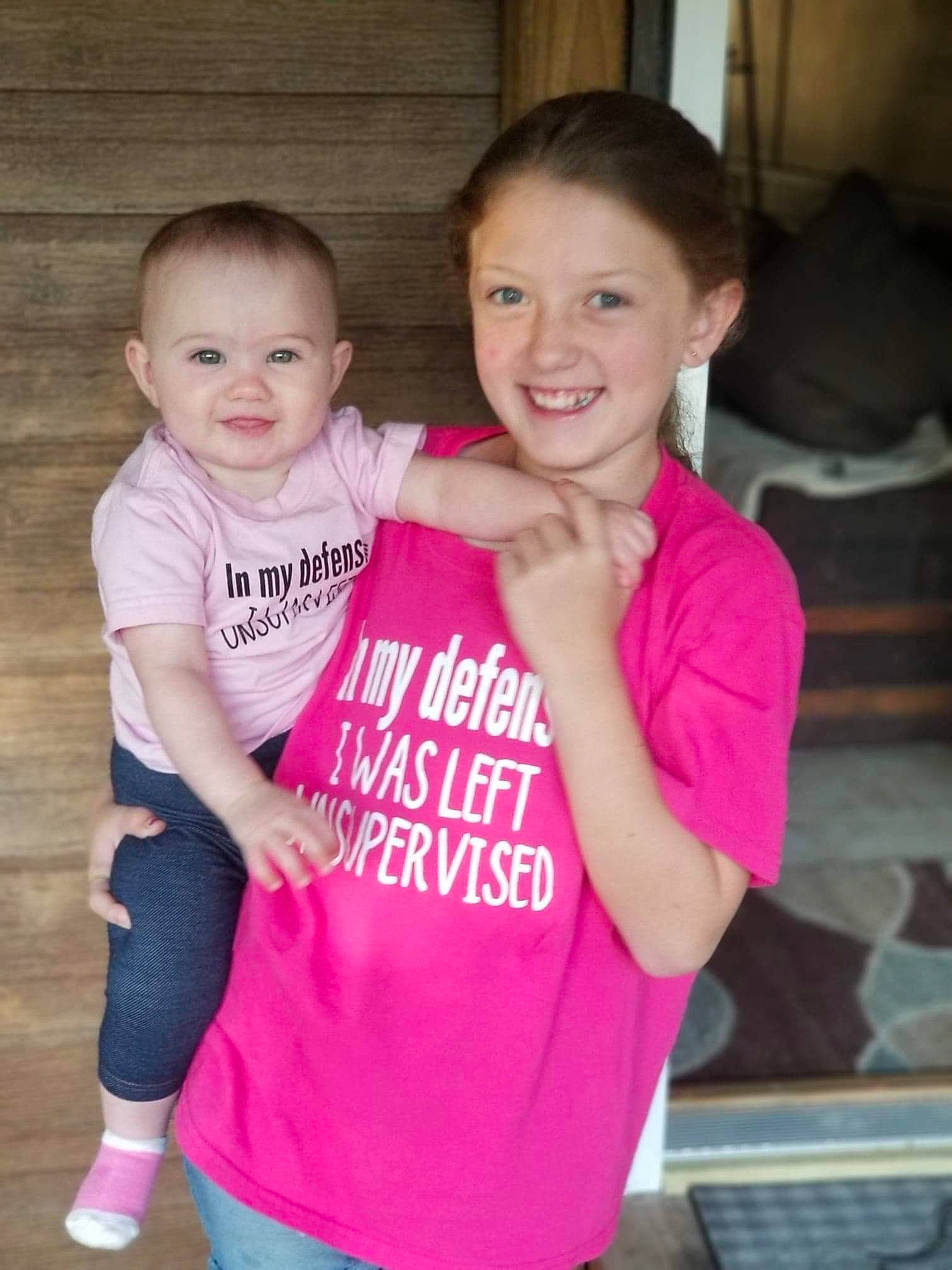 Emmy is registered to the contest to win money with this photo: arm, baby_toddler_clothing, eye, face, facial_expression, gesture, hair, hairstyle, happy, head, human_body, joint, joy, neck, person, pink, shoulder, skin, sleeve, smile