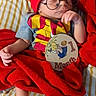 baby, child, cozy, cute, feet, glasses, hand, harry_potter, hat, indoors, infant, milestone_sign, onesie, portrait, red_blanket, resting, sleeping, soft_lighting, striped_bed_sheet, winnie_the_pooh