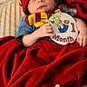 baby, child, cozy, cute, feet, hands, harry_potter_hat, indoors, infant, milestone_card, newborn, one_month, peaceful, portrait, red_blanket, scarf, sleeping, soft_lighting, striped_bed, wrapped