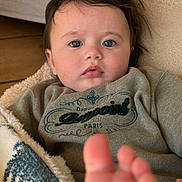Roméo participe au concours pour gagner de l'argent avec cette photo : baby, foot, blanket, blue_eyes, clothing, face, hair, indoor, infant, person, portrait, sitting, toddler, warm, blanket_pattern, expression, cute, soft, skin, cozy