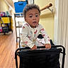 Ryver is registered to the contest to win money with this photo: baby, child, infant, portrait, indoors, hallway, playpen, standing, gripping, curious, surprised, open_mouth, short_hair, patterned_clothing, onesie, home, wood_floor, furniture, photography, adorable
