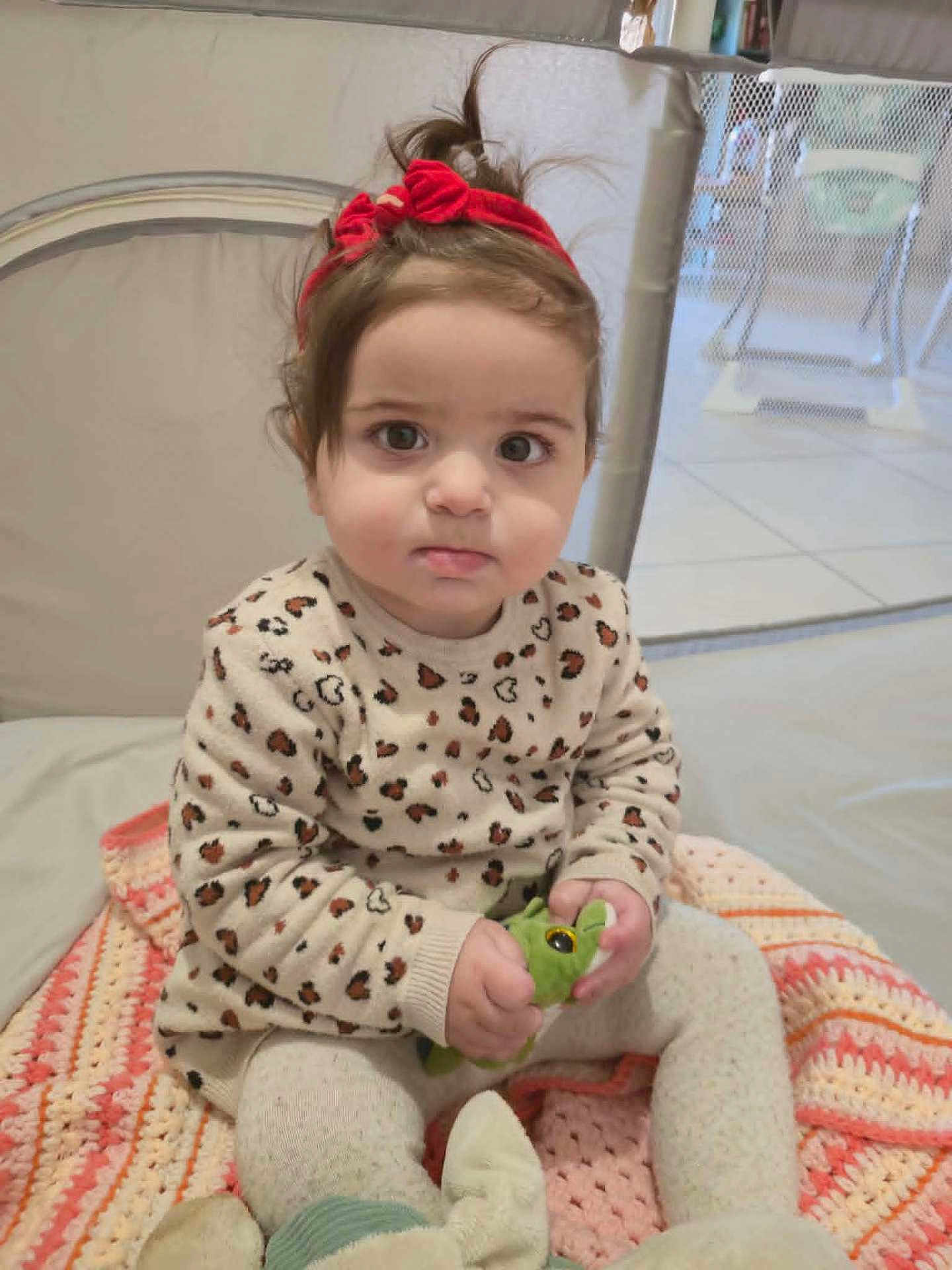 Jasmine a rejoint le concours — aidez-le/la à gagner de superbes lots ! toddler, child, red_headband, leopard_print, sweater, knitted_blanket, plush_toy, indoor, baby, cute, sitting, person, face, expression, hand, floor, home, soft_toys, headwear, young_child