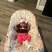 Jhream is registered to the contest to win money with this photo: baby, infant, child, portrait, sitting, bouncer, baby_chair, pink_bow, headband, clothing, black_shirt, pink_pants, bottle, indoor, home, wood_floor, doorway, furniture, awake, serious_expression