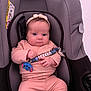 Rose a rejoint le concours — aidez-le/la à gagner de superbes lots ! baby, infant, car_seat, pink_clothing, headband, pacifier_clip, blue_character, cute, child, indoor, seated, clothing, accessory, comfort, young_child, person, portrait, baby_girl, soft_lighting, closeup