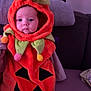 baby, child, costume, halloween, pumpkin, orange, cute, face, expression, sitting, indoor, couch, blanket, plush, hood, festive, holiday, decor, person, portrait