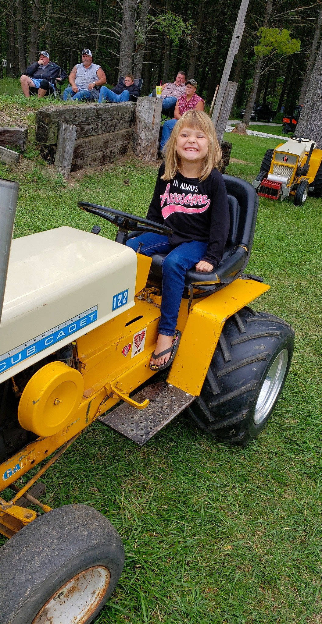 Madaelyn is registered to the contest to win money with this photo: agricultural_machinery, car, grass, joy, land_vehicle, lawn, outdoor_power_equipment, person, tractor, vehicle