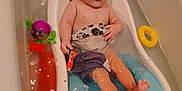 Elieh is registered to the contest to win money with this photo: baby, bathtub, water, toy, bathroom, child, infant, bath, floating_toy, plastic, toddler, skin, naked_upper_body, sitting, bath_toy, yellow_ring, purple_towel, blue_bathtub_insert, cute, relaxing
