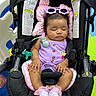 baby, car_seat, child, colorful, cute, headwear, indoor, infant, pacifier, pink_socks, play_mat, purple_outfit, relaxation, resting, seatbelt, sleeping, soft_toys, sunglasses, toddler, toy