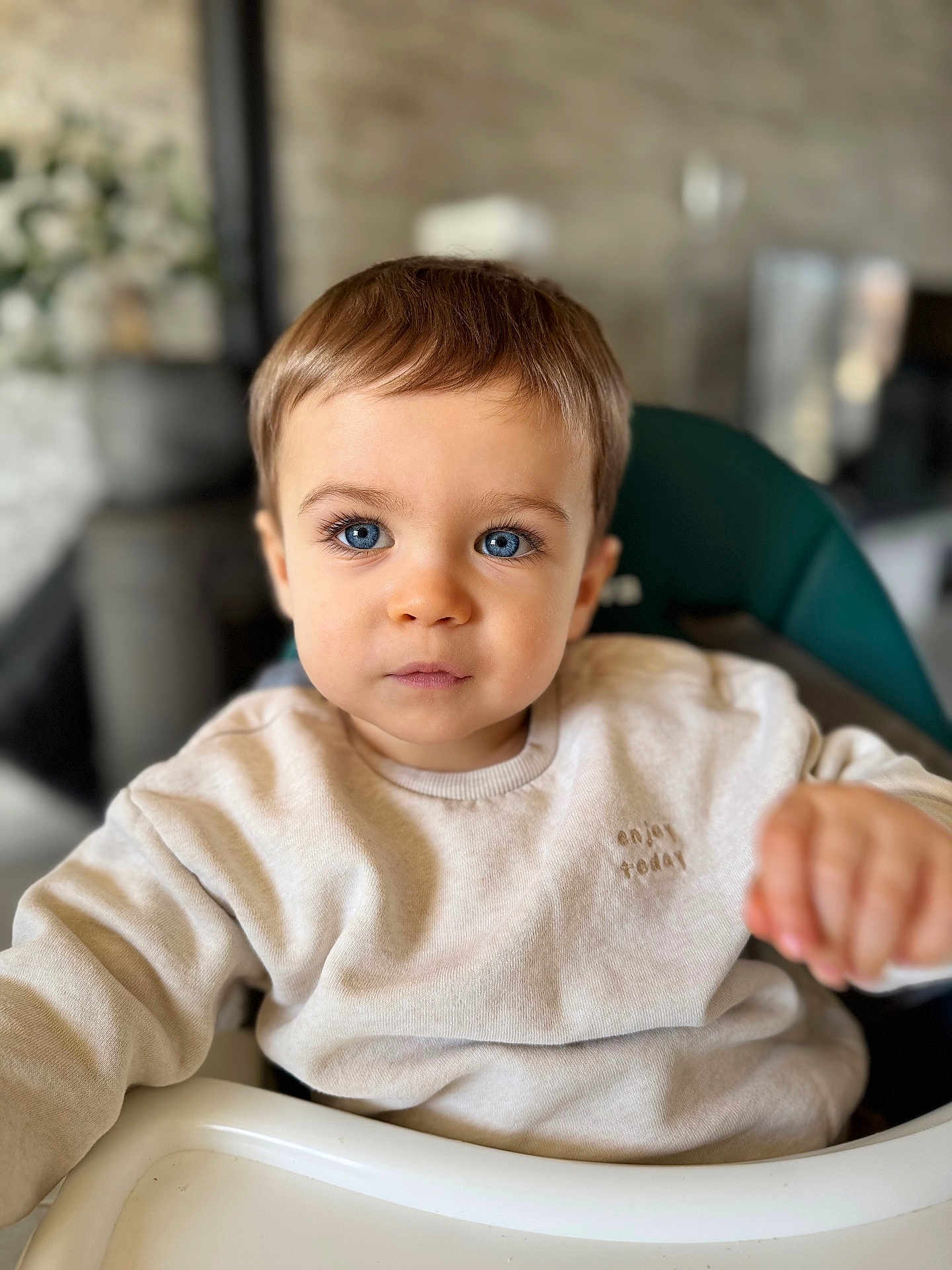Gabriel participe au concours pour gagner de l'argent avec cette photo : toddler, child, blue_eyes, high_chair, beige_sweater, indoor, portrait, person, cute, face, young_child, baby, clothing, expression, sitting, soft_lighting, background_blur, curious, close_up, eyelashes