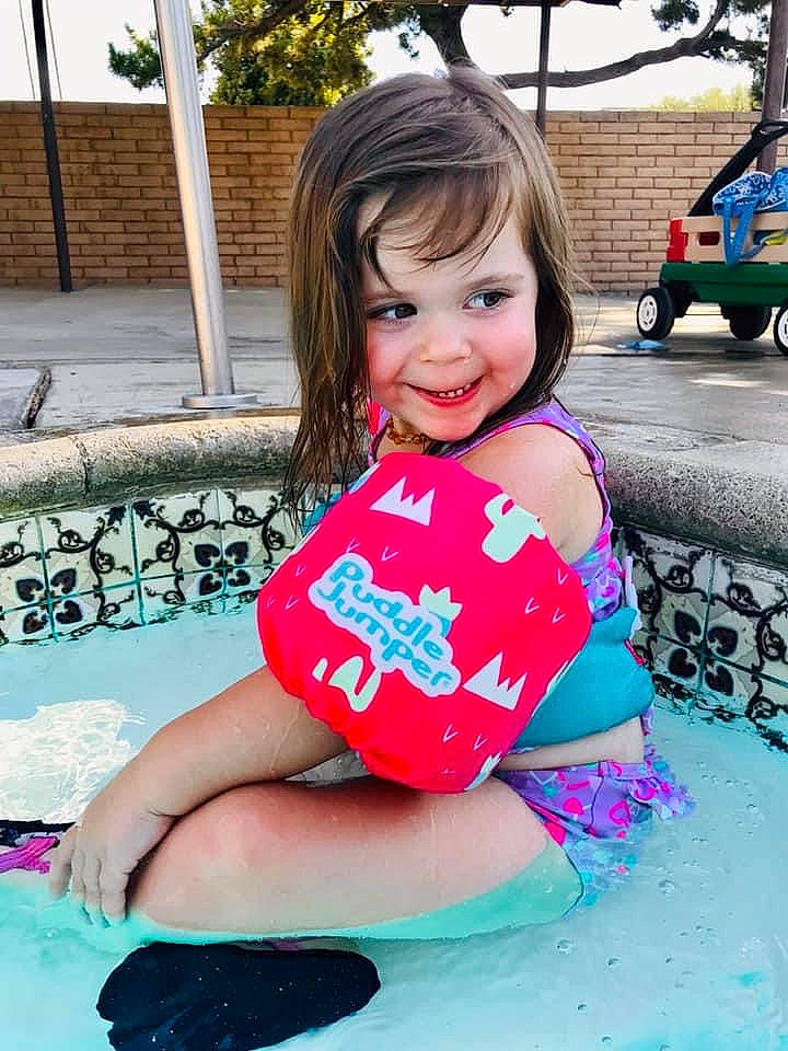 Poppy is registered to the contest to win money with this photo: aqua, automotive_tire, azure, baby_toddler_clothing, blue, clothing, electric_blue, fun, happy, joy, leisure, magenta, person, photograph, pink, recreation, smile, t_shirt, tire, toddler