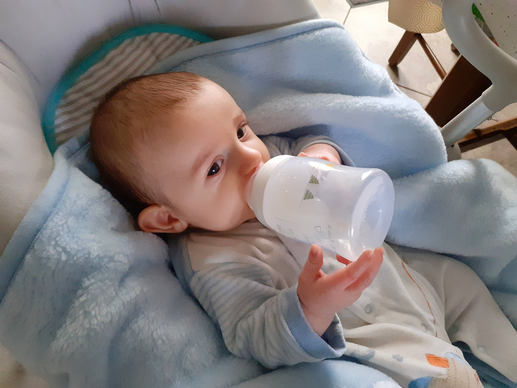 Ezekiel participe au concours pour gagner de l'argent avec cette photo : baby, baby_bottle, baby_products, baby_toddler_clothing, chair, cheek, child, chin, comfort, drinking, drinkware, eyebrow, eyelash, milk, mouth, nose, person, plant_milk, skin, toddler