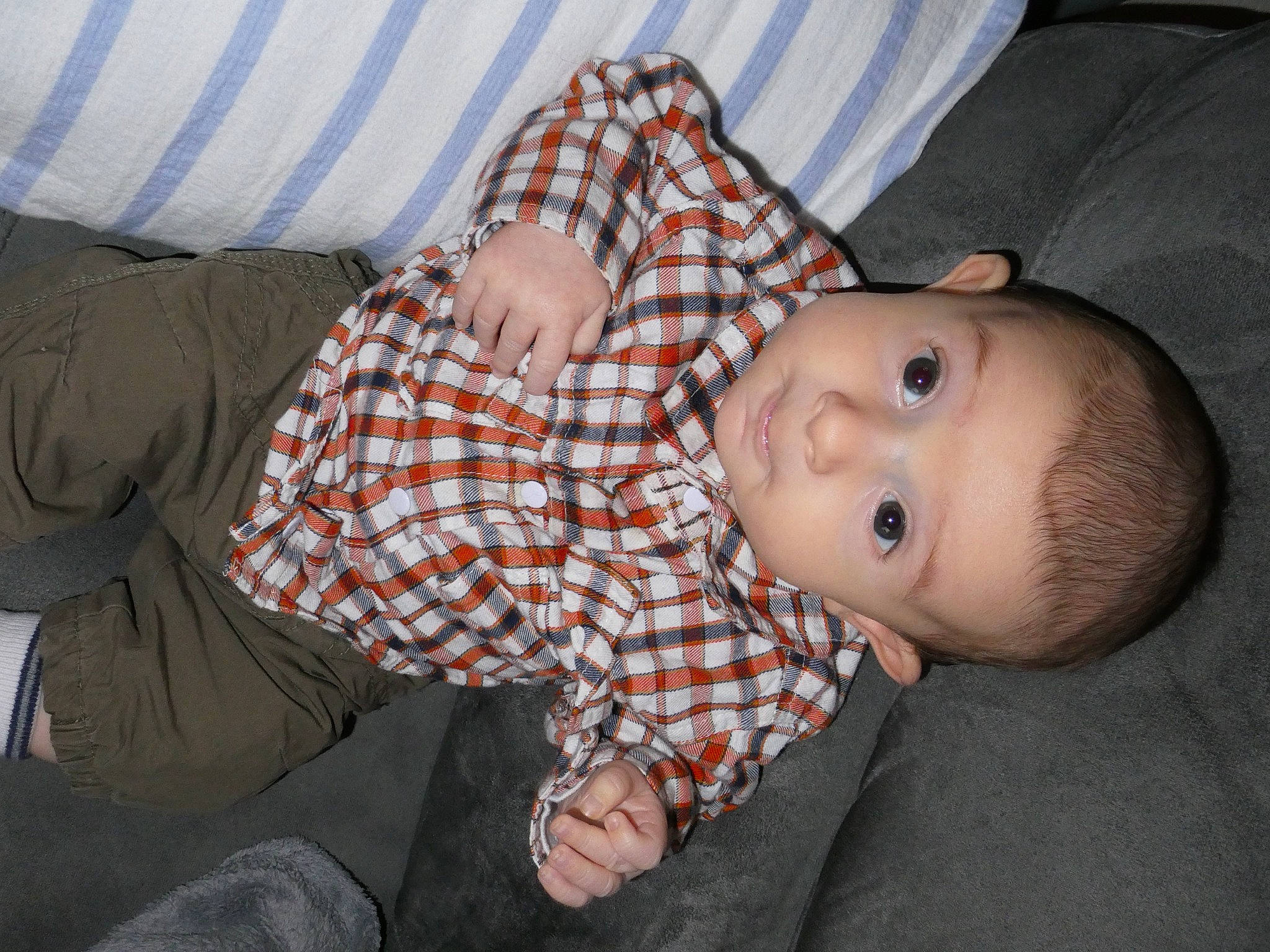 Ezekiel participe au concours pour gagner de l'argent avec cette photo : baby, baby_toddler_clothing, cheek, child, comfort, elbow, facial_expression, finger, fun, head, mouth, nose, pattern, person, plaid, sitting, skin, sleeve, tartan, toddler
