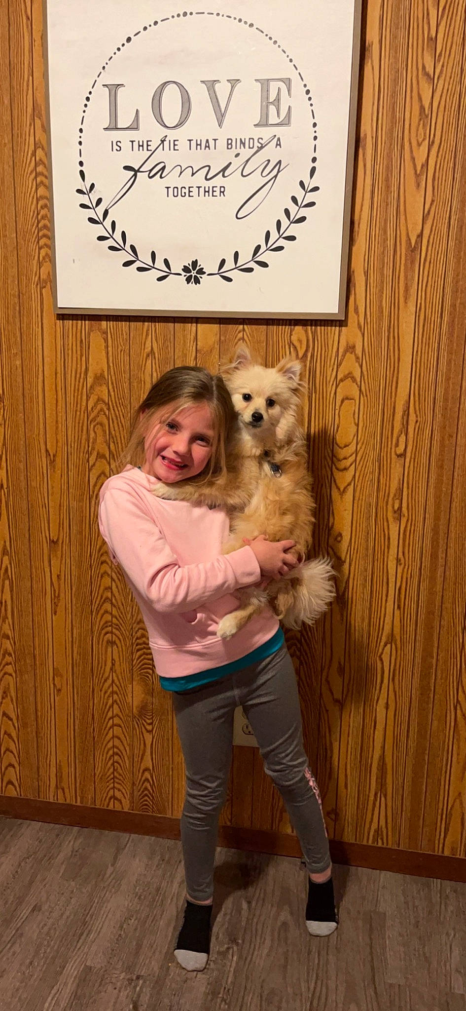 Abigail is registered to the contest to win money with this photo: blond, canidae, carnivore, child, companion_dog, dog, dog_breed, dog_supply, fawn, flooring, fur, happy, hardwood, joy, mammal, person, pet_supply, smile, standing, thigh