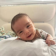 Jordan joined the competition — help win amazing prizes! baby, smiling, face, dimples, infant, cute, lying_down, soft, white, blanket, bed, child, person, portrait, indoors, happy, closeup, young, skin, casual_clothing