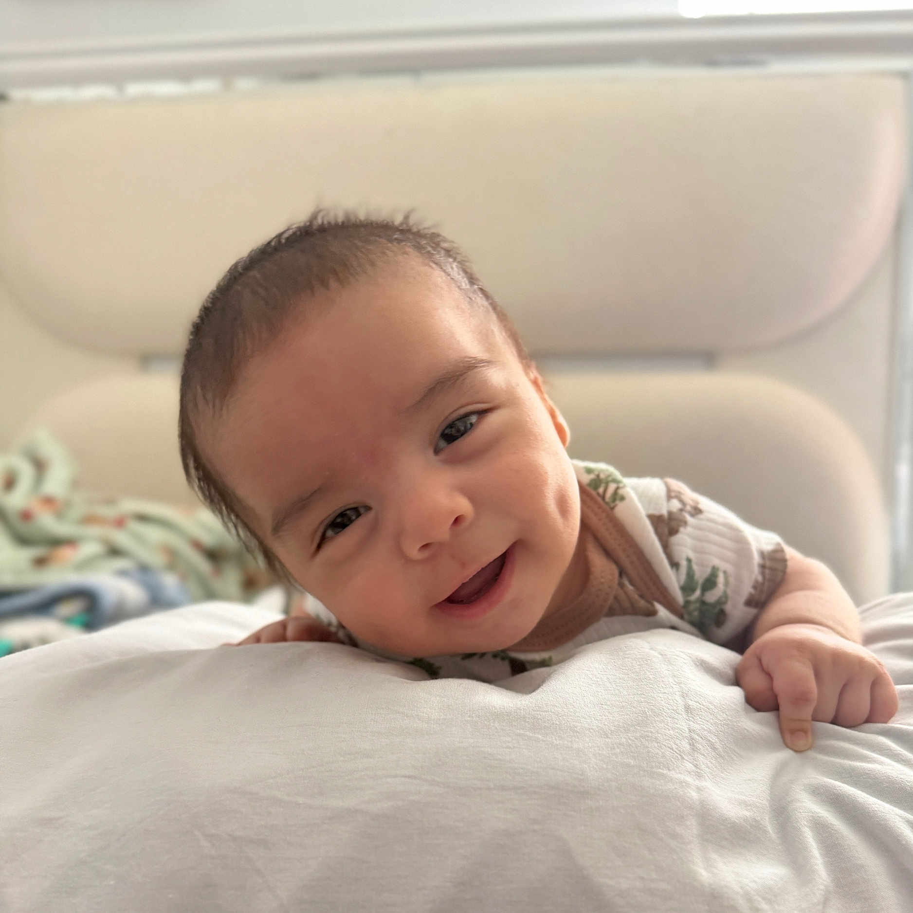 Jordan joined the competition — help win amazing prizes! baby, smiling, face, dimples, infant, cute, lying_down, soft, white, blanket, bed, child, person, portrait, indoors, happy, closeup, young, skin, casual_clothing