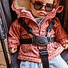 baby, child, sunglasses, pink_jacket, stroller, cute, fashion, outdoor, warm_clothing, infant, seatbelt, blue_pants, heart_pattern, baby_fashion, cute_baby, leopard_print, baby_accessories, portrait, baby_face, casual
