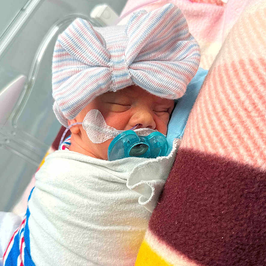 Serena joined the competition — help win amazing prizes! architecture, baby, bed, blanket, bodypart, bonnet, building, clothing, face, finger, furniture, glove, hat, head, hospital, newborn, person, photography, portrait, sleeping