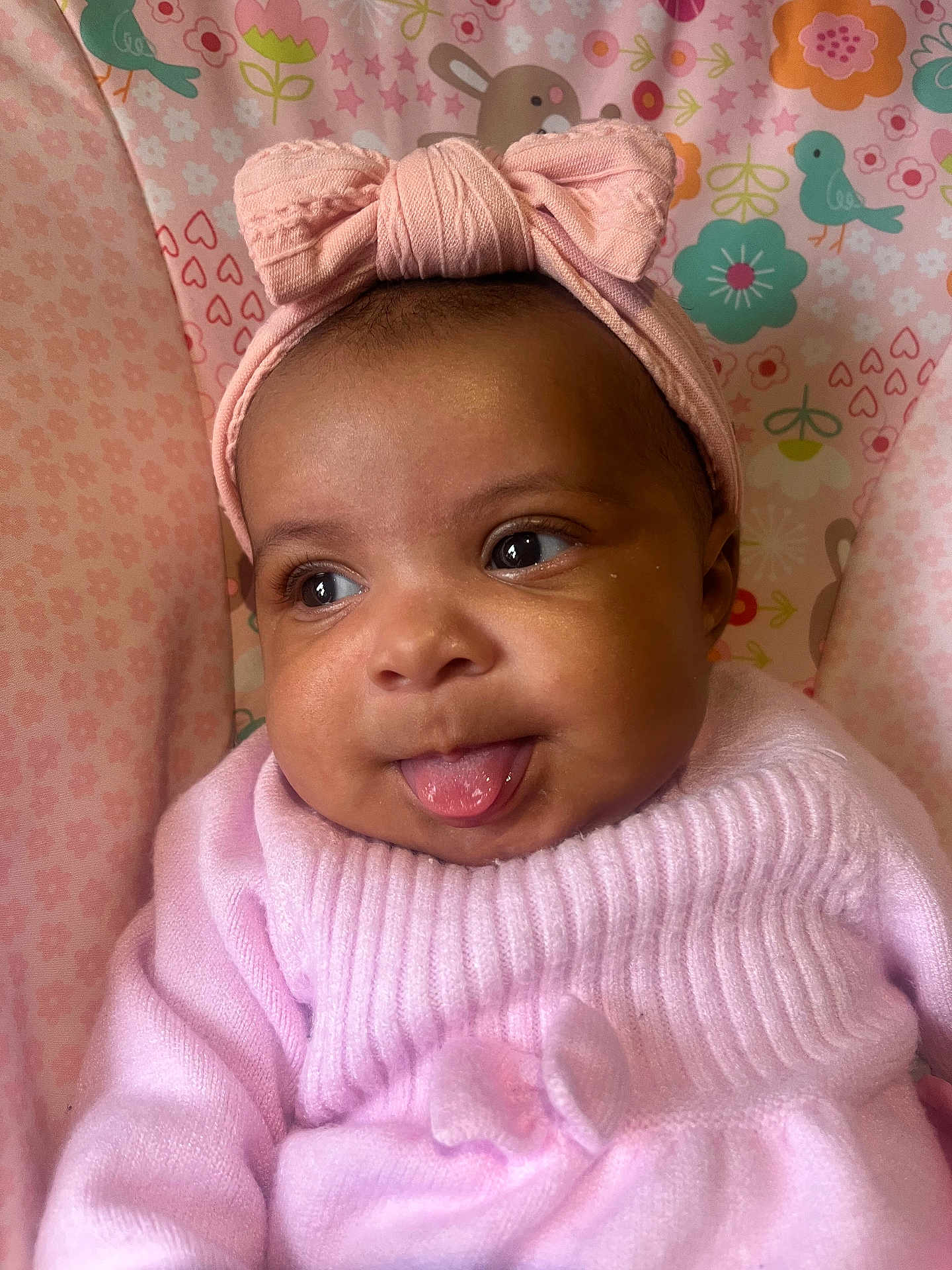 Aniyah joined the competition — help win amazing prizes! baby, child, pink_headband, bow, pink_sweater, tongue_out, cute, infant, face, smiling, patterned_background, birds, flowers, hearts, close_up, portrait, soft_texture, happy, indoors, cozy