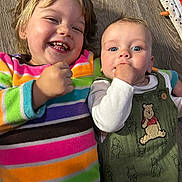 Nathan joined the competition — help win amazing prizes! child, baby, smiling, laughing, floor, wooden_floor, rainbow_stripe, sweater, green_outfit, winnie_the_pooh, infant, happy, cute, two_kids, closeup, portrait, indoor, candid, playful, fist_in_mouth
