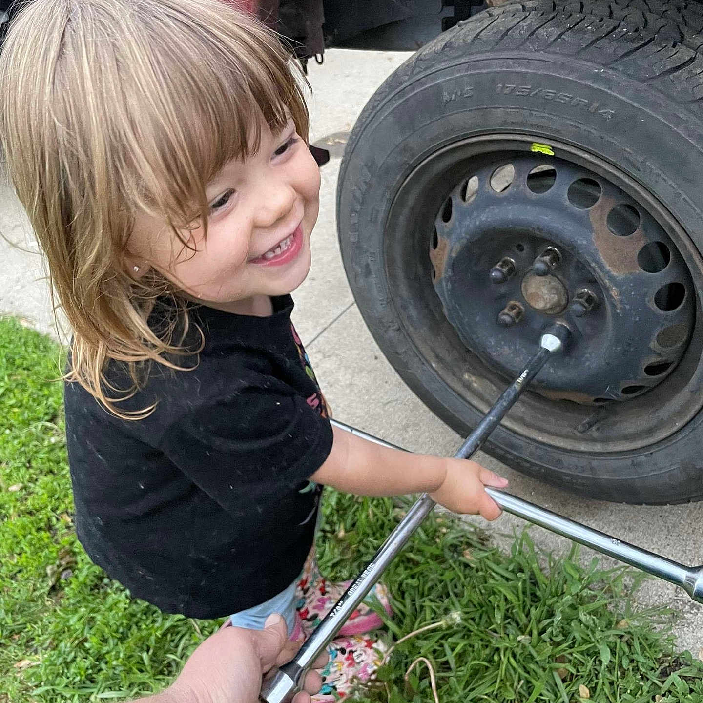Serenity joined the competition — help win amazing prizes! assistance, automobile, black_shirt, car, child, concrete, grass, hand, happy, helping, outdoor, person, pink_boots, playful, smiling, tire, tool, vehicle, wheel, wrench