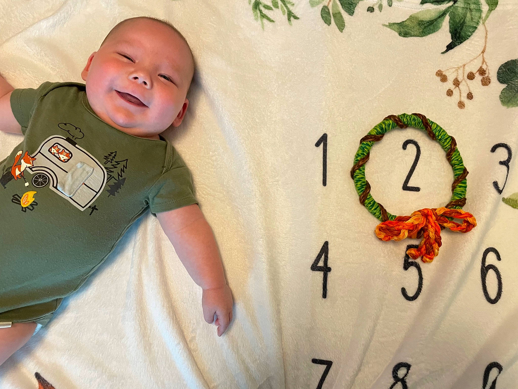 Ryder is registered to the contest to win money with this photo: baby, baby_products, baby_toddler_clothing, child, comfort, design, facial_expression, font, green, happy, illustration, linens, neck, pattern, people_in_nature, person, sleeve, smile, t_shirt, textile