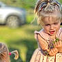 Daniella is registered to the contest to win money with this photo: child, girl, pigtails, pink_dress, outdoor, plants, twigs, greenery, sunlight, blurry_background, car, curious, nature, summer, portrait, two_children, playing, daylight, cute, fun
